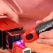 a person holding a red and black electronic device