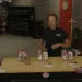Larry Stogner sitting at a table with a group of cans and bottles